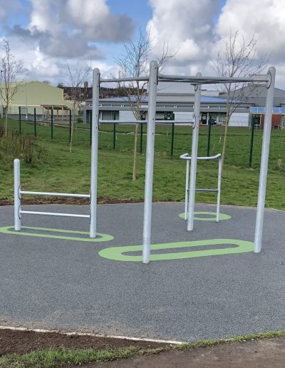 Outdoor gym installation with metal bar frames and new surfacing.